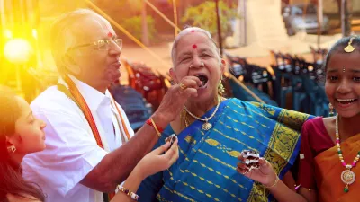Photo of an older person joyfully being fed cake