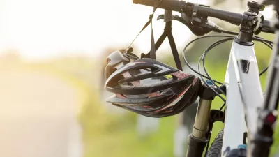 Photo of a bicycle and helmet in focus with a sunny background