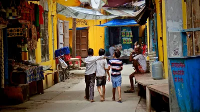 three boys walking down a street in India