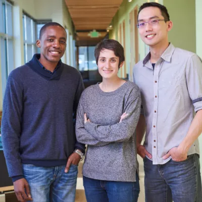 Three IHME employees stand together in the office